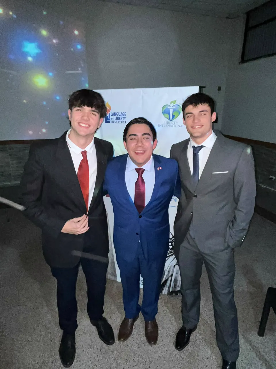 Three young men in suits at an international conference
